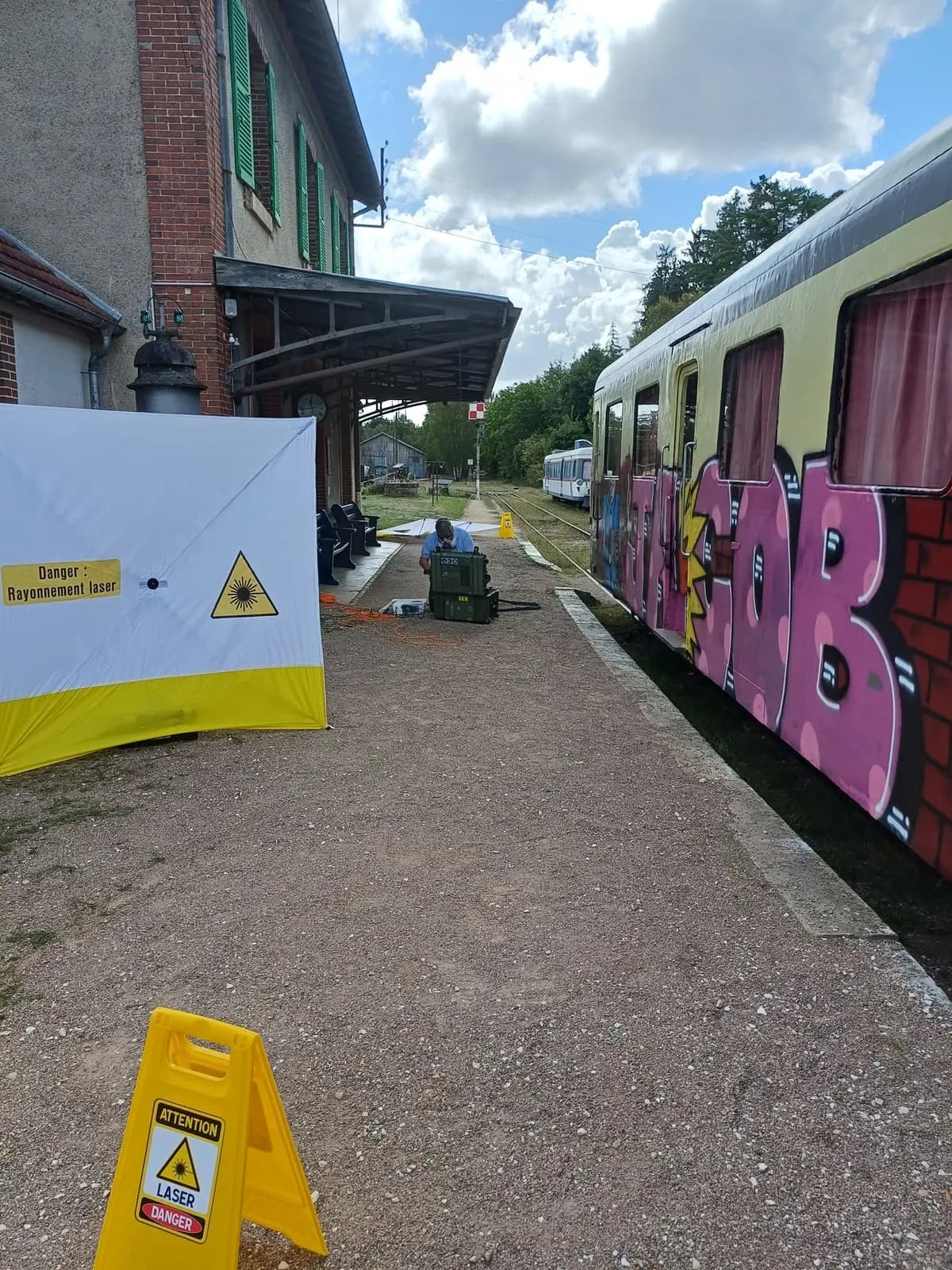 Graffiti-covered AATY RGP 2 trainset with Raynovation Laser equipment and work-area signage in Toucy