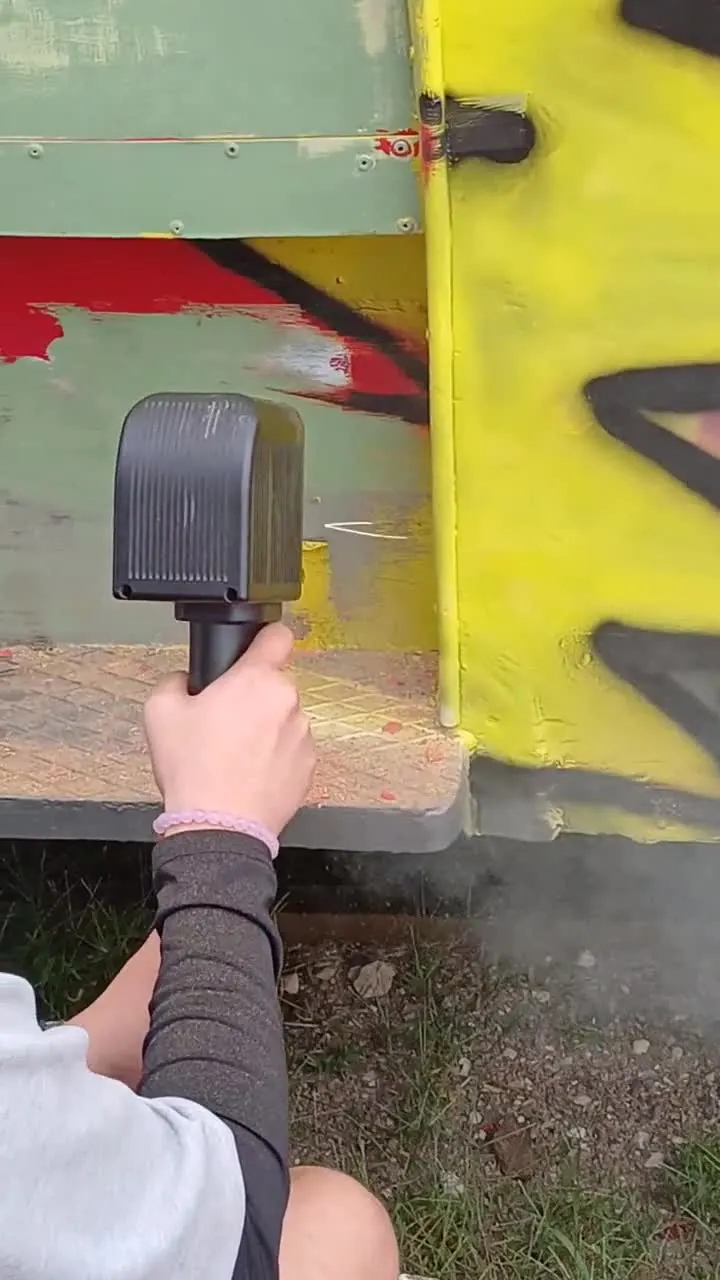 Close-up treatment of a bodywork area carrying several graffiti colours. Laser passes produce visible differences in the treated surfaces.